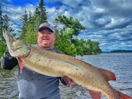 Man Lifting Up Giant Muskie Caught Fishing